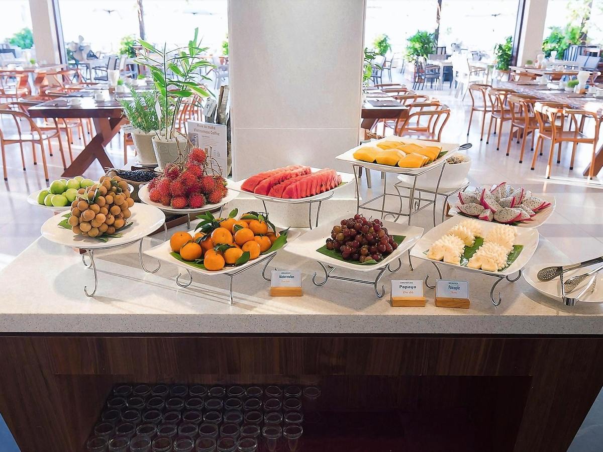 Breakfast buffet counter with platters of watermelon, dragon fruit and other tropical fruit